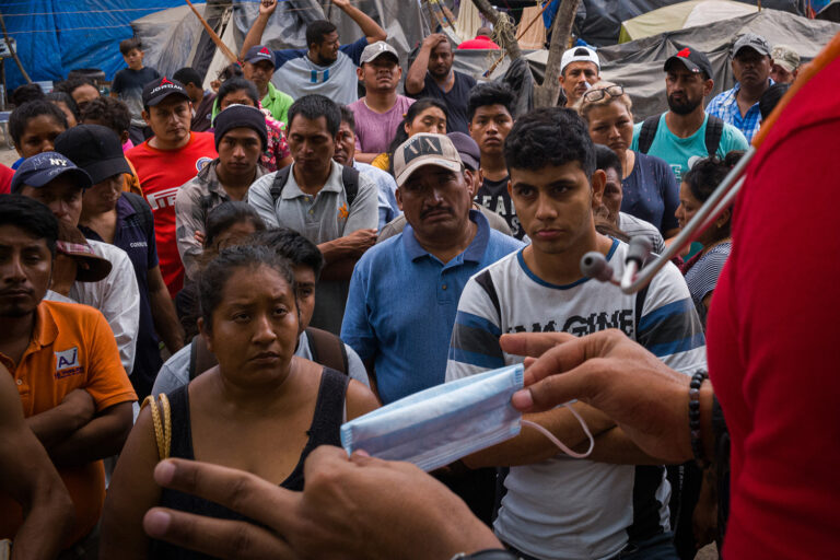 A doctor warns those in the refugee camp in Matamoros, Mexico, about the dangers of Covid-19 on March 18, 2020. Photo by Ivan Flores for Foreign Policy.