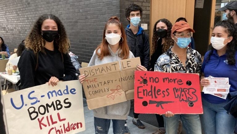 Protesters are pictured holding signs in the SEC on Apr. 25, 2022. Chloe Courtney Bohl / The Tufts Daily